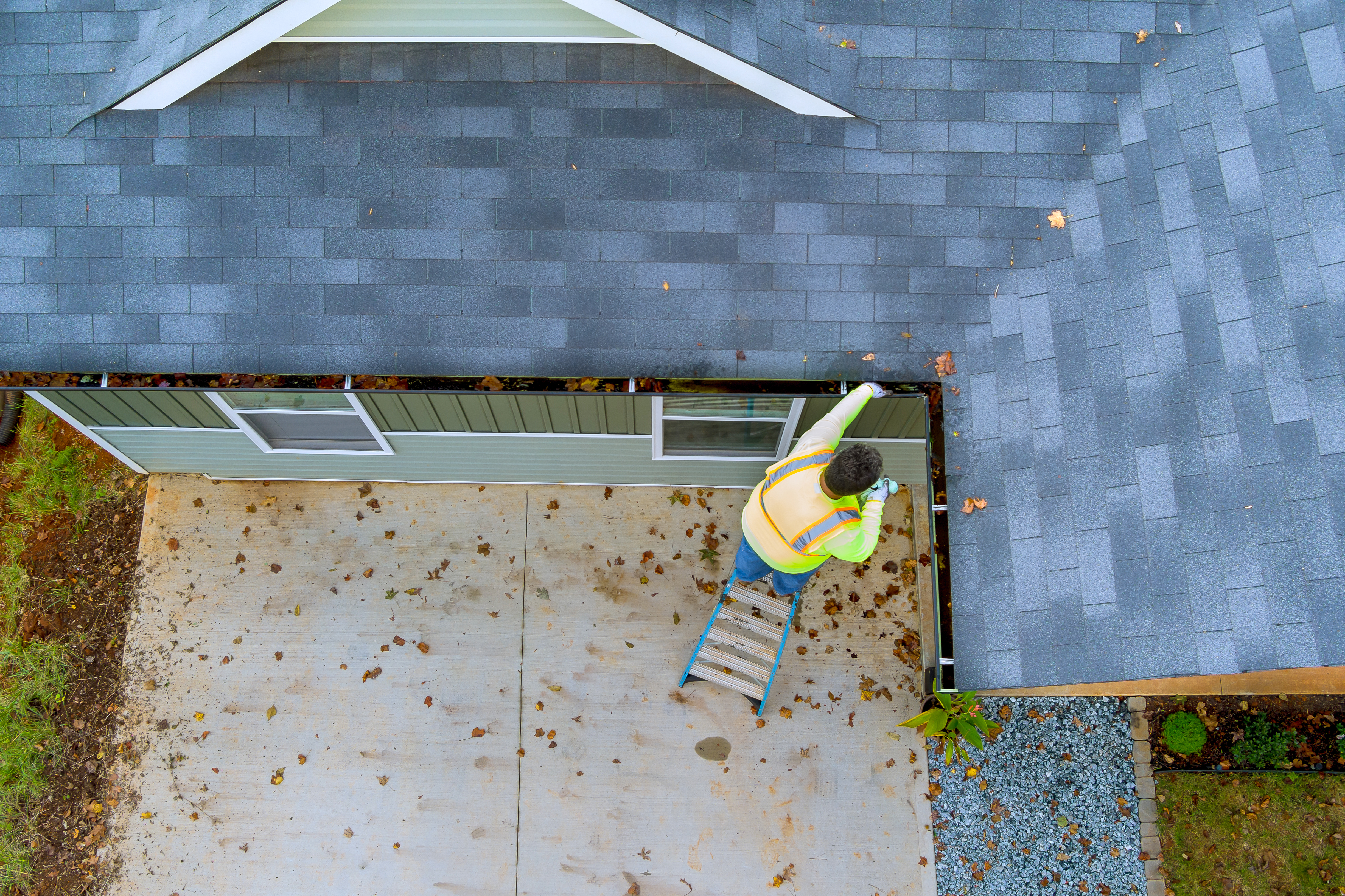 Professional cleaning a clogged roof gutter drain